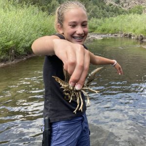 A happy child catches a crayfish at survival class
