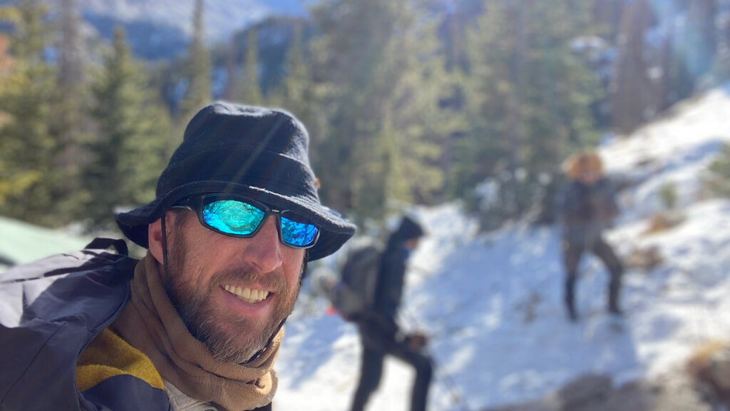 Backcountry hikers moving through snowy terrain in Colorado during cold weather where hypothermia can develop gradually during travel