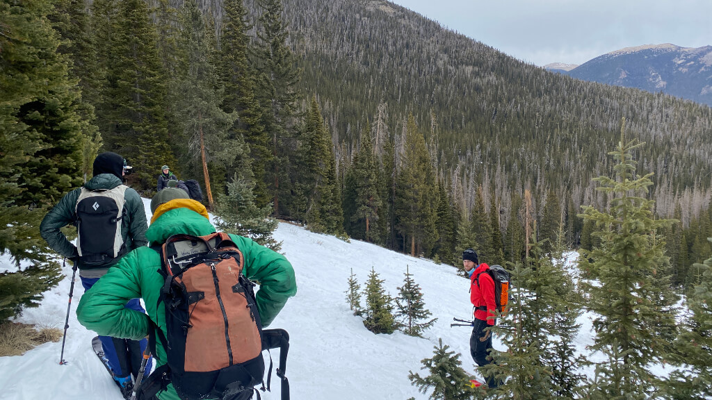 Group hiking in snowy mountain terrain where subtle coordination and judgment errors can signal early hypothermia