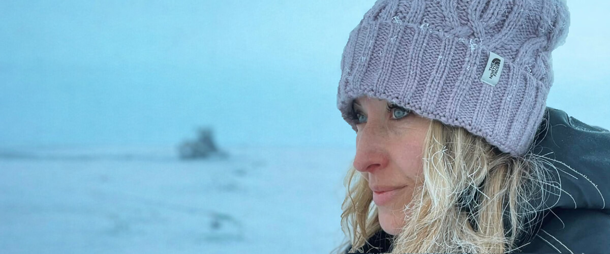 Jess Caldwell standing alert in a cold outdoor environment, illustrating intuition and situational awareness through focused attention.