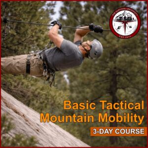 Man wearing helmet and harness traversing a fixed rope line across a granite slope in a Colorado mountain forest environment.