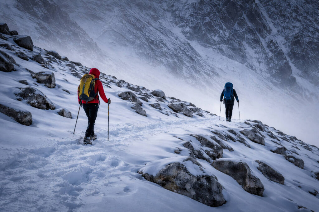 Two hikers moving apart on a mountain trail, illustrating loss of group cohesion and shared decision making