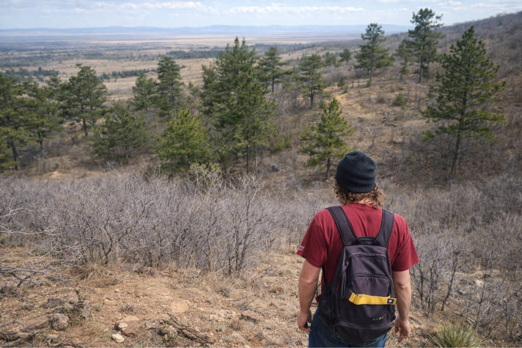 Hiker walking through steep off trail terrain while trying to navigate after losing the trail