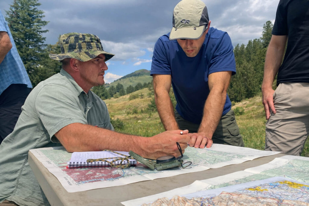 Students learning map and compass navigation during wilderness leadership and survival training course