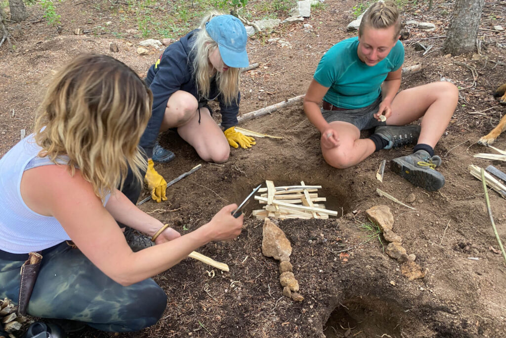 Students practicing fire lay construction during wilderness survival training to build repetition and skill