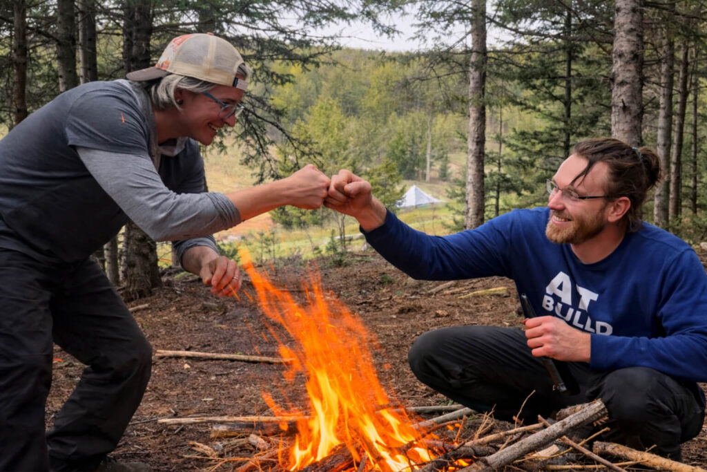 Students successfully starting a campfire during wilderness survival skills training in Colorado
