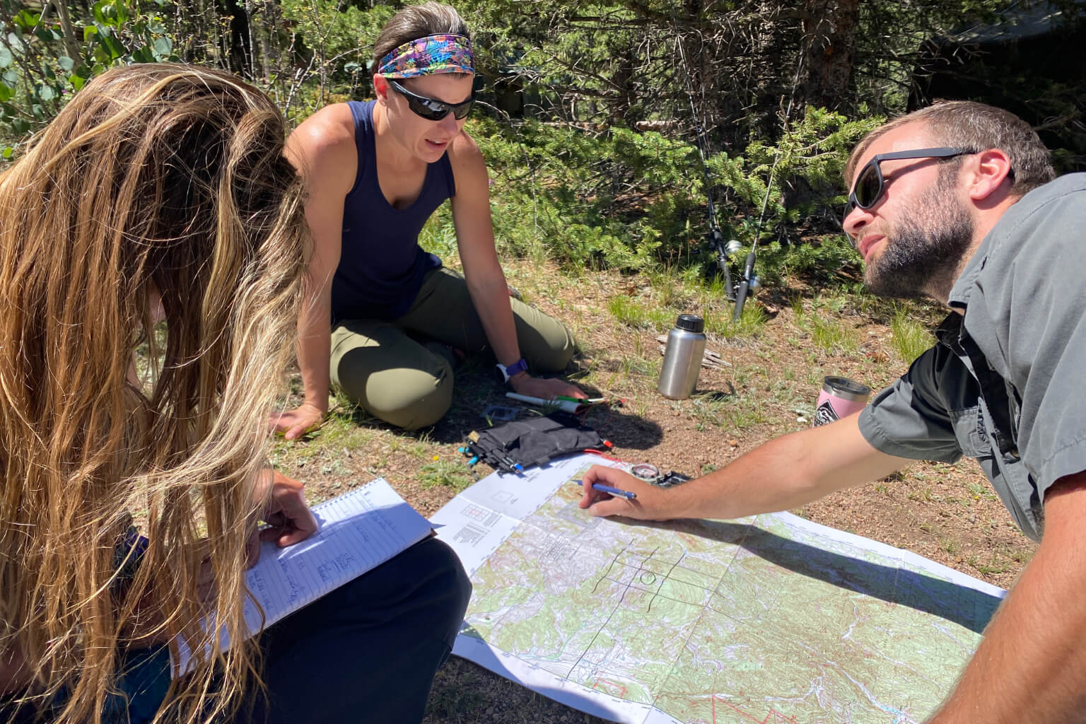 Small group working together over a map to make navigation decisions during outdoor team training