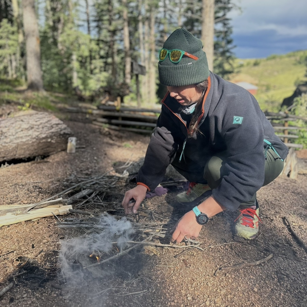Student working to build a small survival fire during a wilderness survival class in Colorado