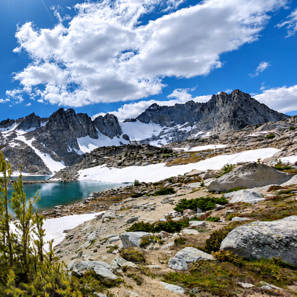 Granite peaks, snowfields, and a turquoise alpine lake in the Enchantments, Washington.